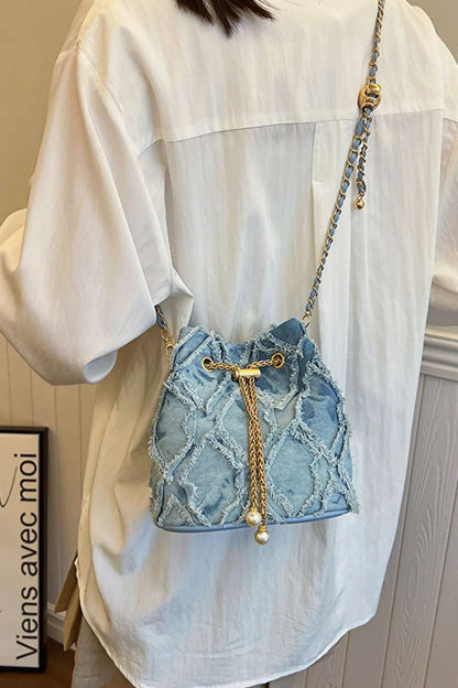 Chain Drawstring Raw Edge Denim Bucket Bag - Premium Crossbody Bag from Trendsi - Just $34.99! Shop now at Handbags Specialist Headquarter