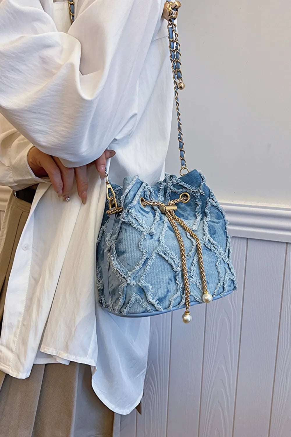 Chain Drawstring Raw Edge Denim Bucket Bag - Premium Crossbody Bag from Trendsi - Just $34.99! Shop now at Handbags Specialist Headquarter