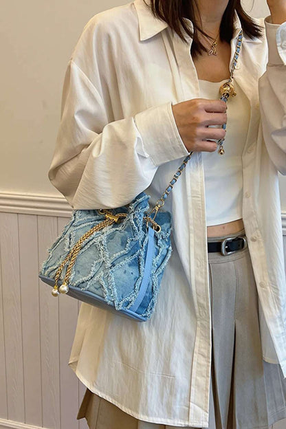 Chain Drawstring Raw Edge Denim Bucket Bag - Premium Crossbody Bag from Trendsi - Just $34.99! Shop now at Handbags Specialist Headquarter