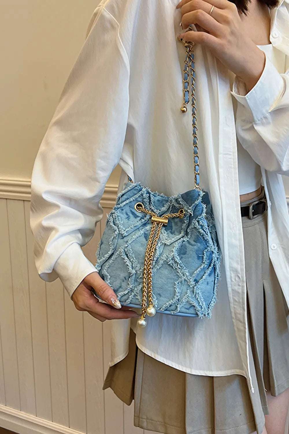 Chain Drawstring Raw Edge Denim Bucket Bag - Premium Crossbody Bag from Trendsi - Just $34.99! Shop now at Handbags Specialist Headquarter