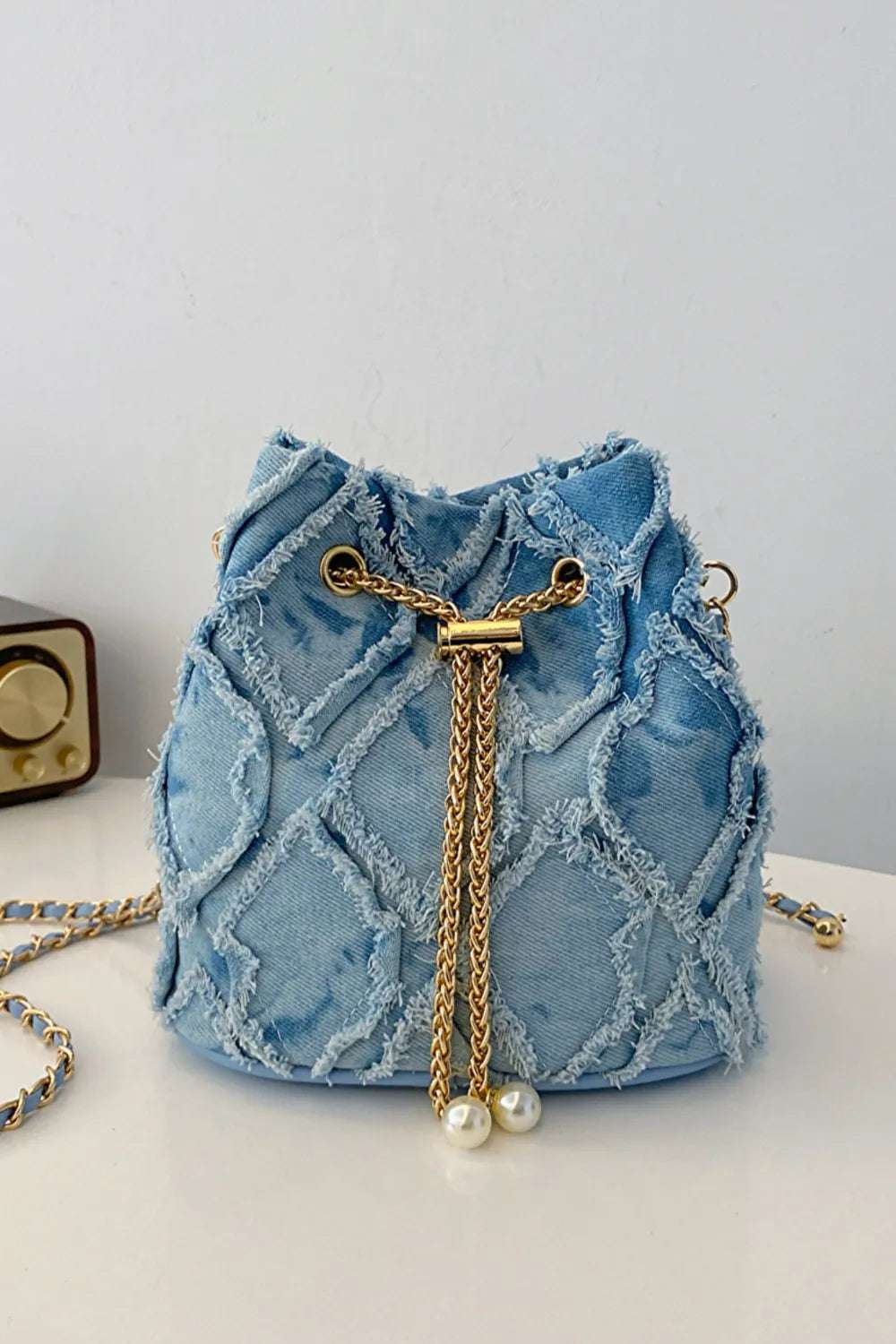 Chain Drawstring Raw Edge Denim Bucket Bag - Premium Crossbody Bag from Trendsi - Just $34.99! Shop now at Handbags Specialist Headquarter