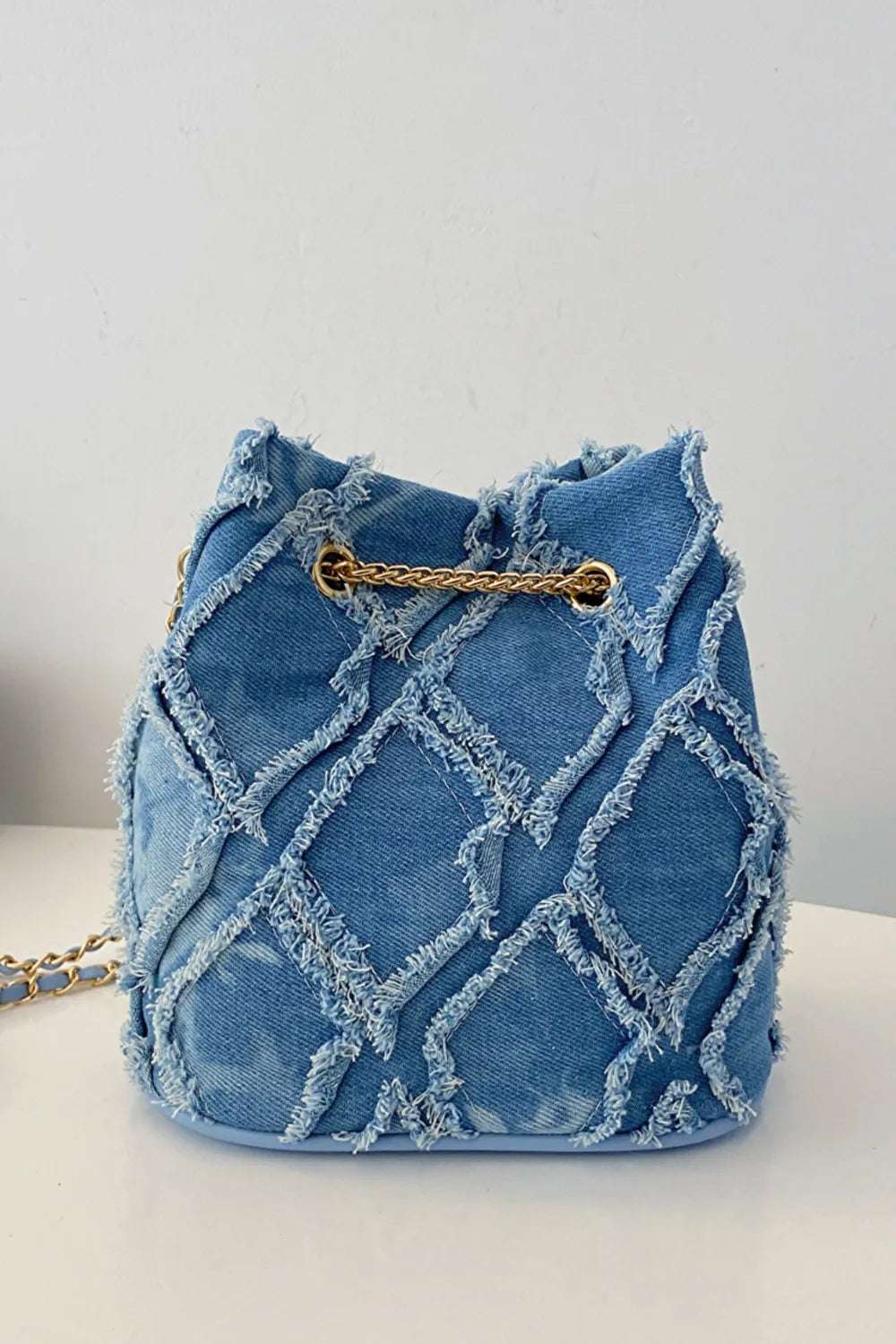 Chain Drawstring Raw Edge Denim Bucket Bag - Premium Crossbody Bag from Trendsi - Just $34.99! Shop now at Handbags Specialist Headquarter