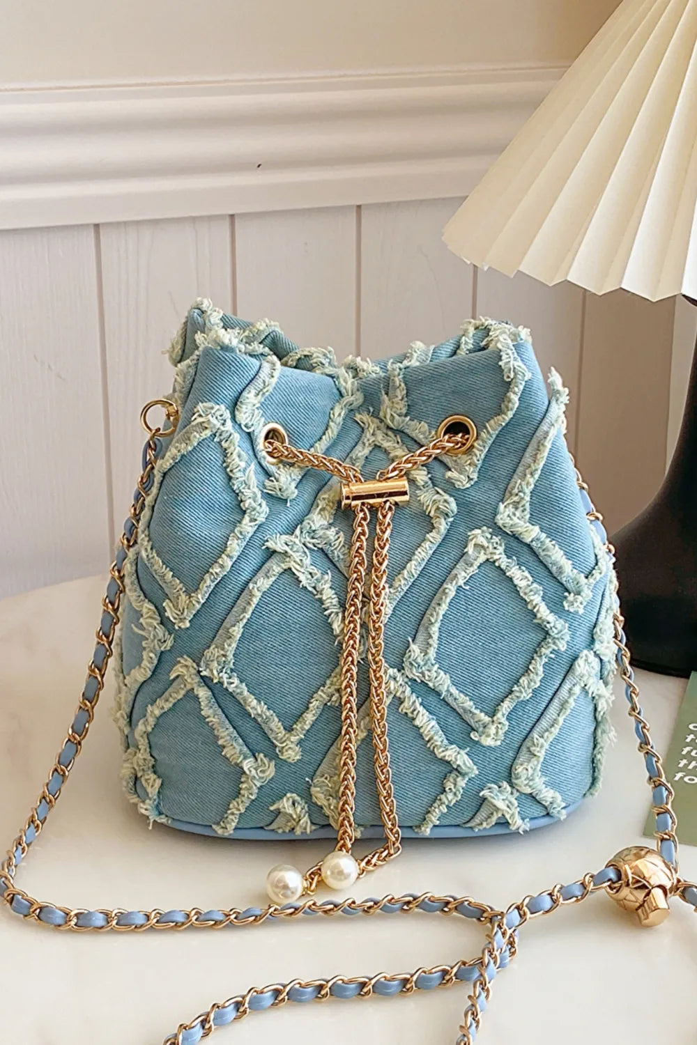 Chain Drawstring Raw Edge Denim Bucket Bag - Premium Crossbody Bag from Trendsi - Just $34.99! Shop now at Handbags Specialist Headquarter