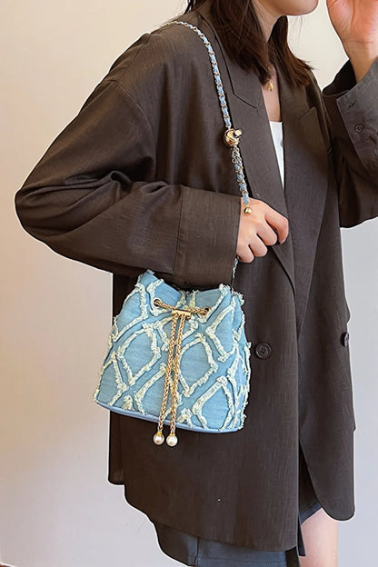 Chain Drawstring Raw Edge Denim Bucket Bag - Premium Crossbody Bag from Trendsi - Just $34.99! Shop now at Handbags Specialist Headquarter