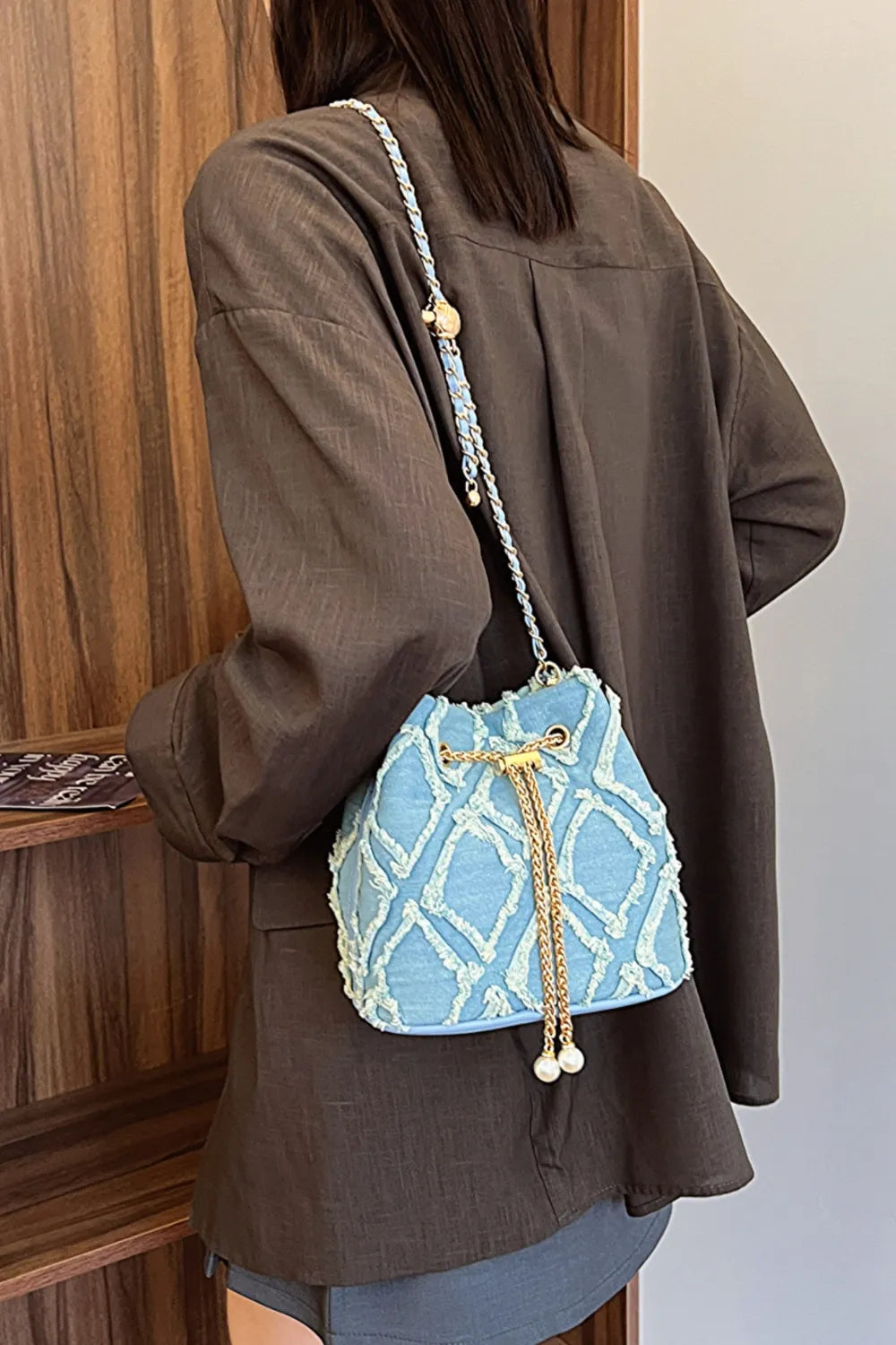 Chain Drawstring Raw Edge Denim Bucket Bag - Premium Crossbody Bag from Trendsi - Just $34.99! Shop now at Handbags Specialist Headquarter