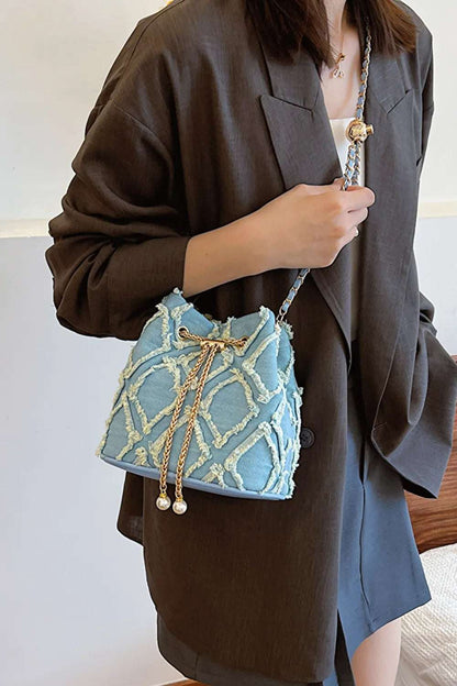 Chain Drawstring Raw Edge Denim Bucket Bag - Premium Crossbody Bag from Trendsi - Just $34.99! Shop now at Handbags Specialist Headquarter