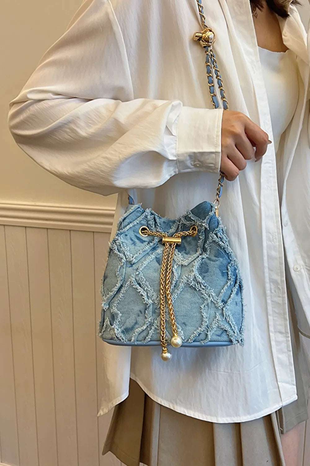 Chain Drawstring Raw Edge Denim Bucket Bag - Premium Crossbody Bag from Trendsi - Just $34.99! Shop now at Handbags Specialist Headquarter