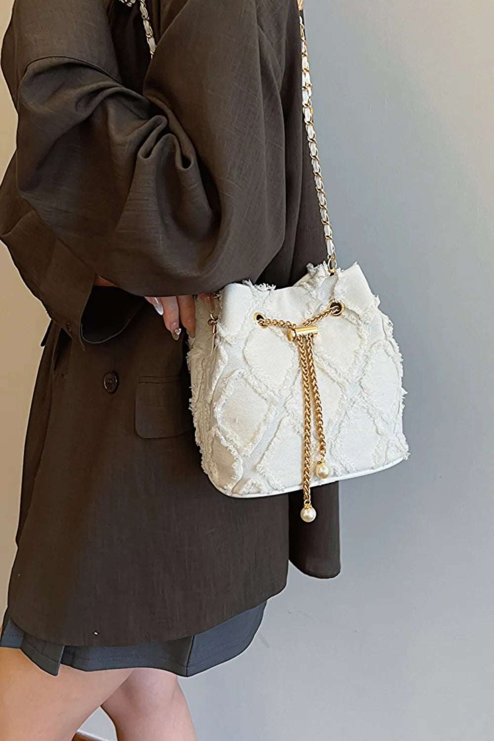 Chain Drawstring Raw Edge Denim Bucket Bag - Premium Crossbody Bag from Trendsi - Just $34.99! Shop now at Handbags Specialist Headquarter