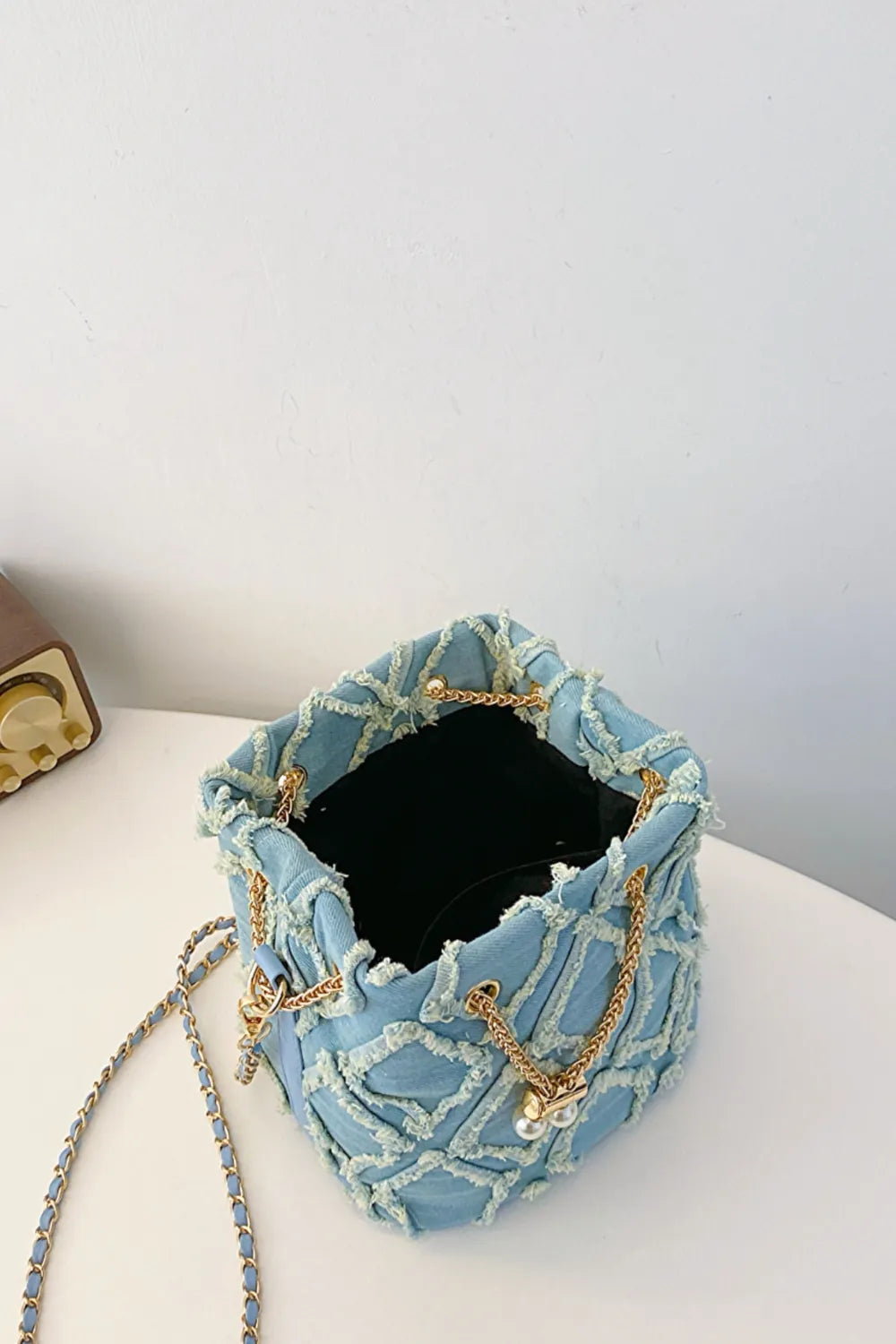 Chain Drawstring Raw Edge Denim Bucket Bag - Premium Crossbody Bag from Trendsi - Just $34.99! Shop now at Handbags Specialist Headquarter